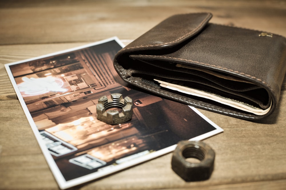braunes Leder Bifold Portemonnaie auf braunem Holztisch