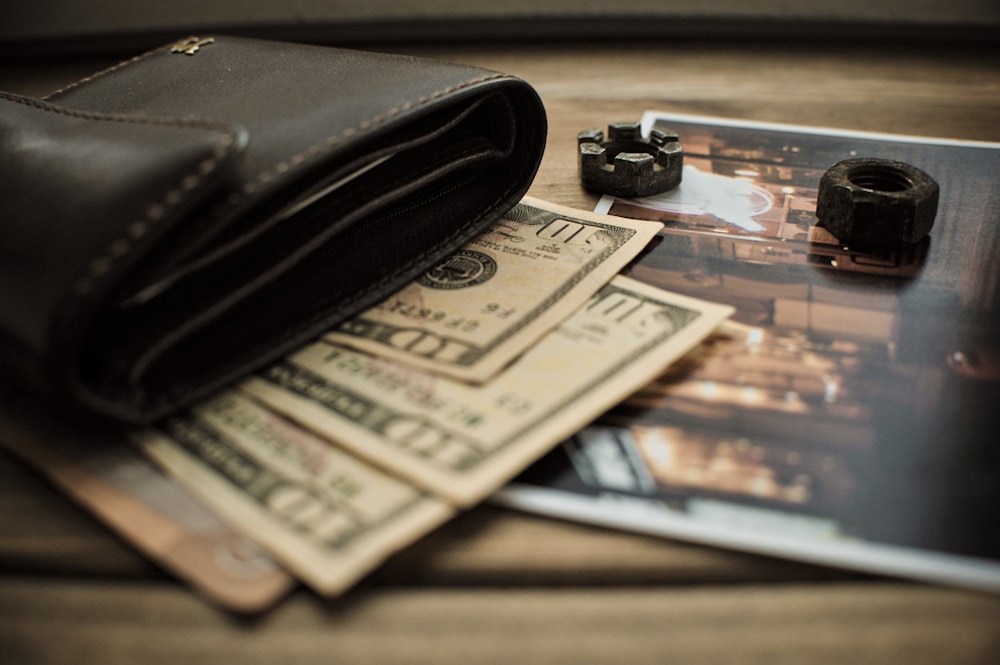 black leather bifold wallet on banknotes