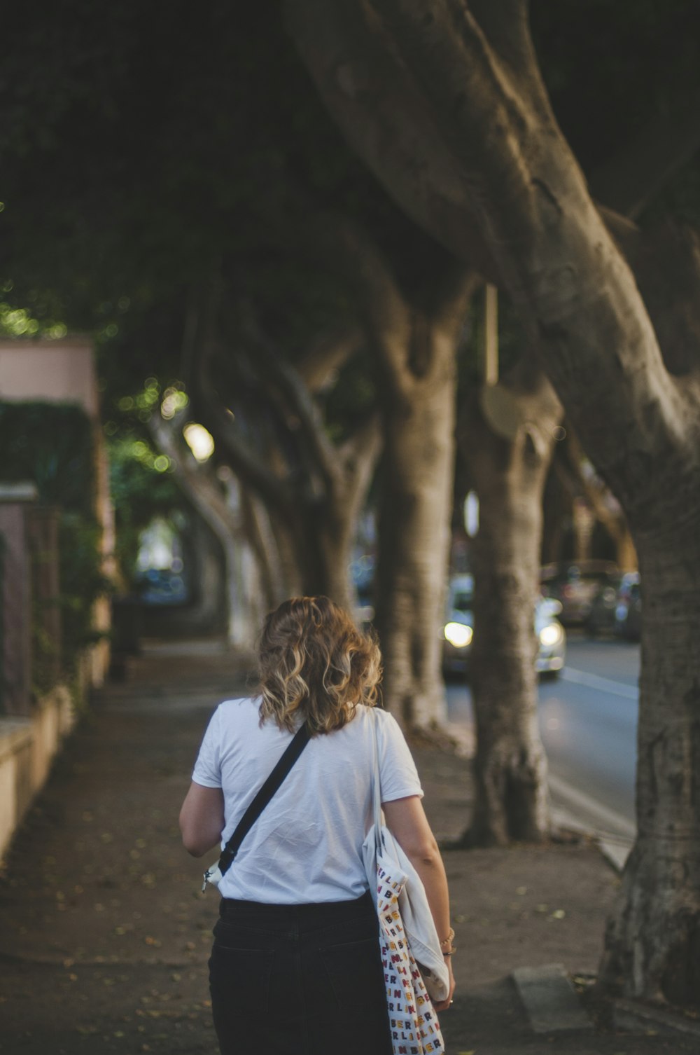 woman in white t-shirt standing near tree during night time