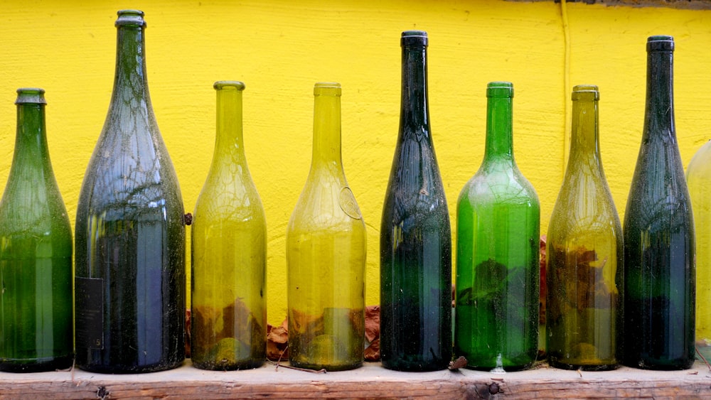 green glass bottles on brown wooden table