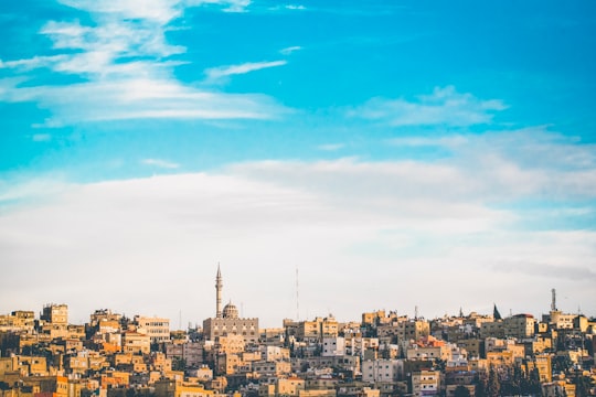 city buildings under blue sky during daytime in Amman Jordan