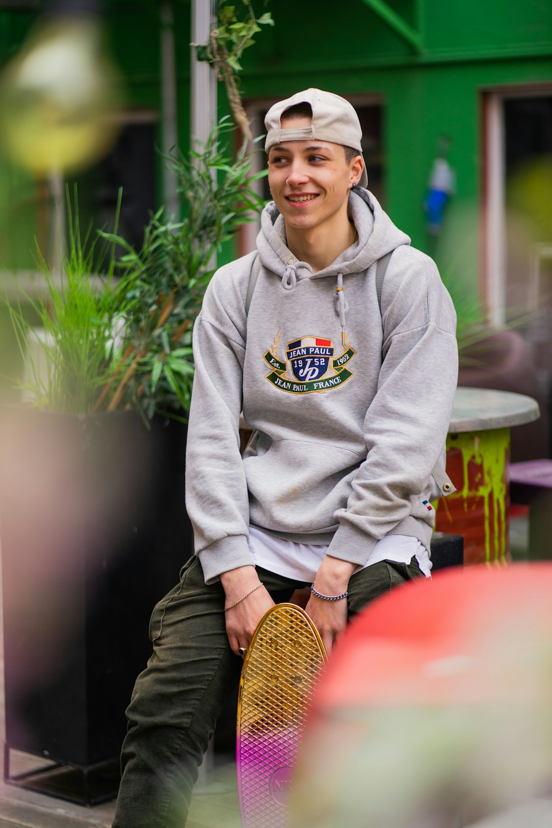 man in gray hoodie sitting on chair smiling