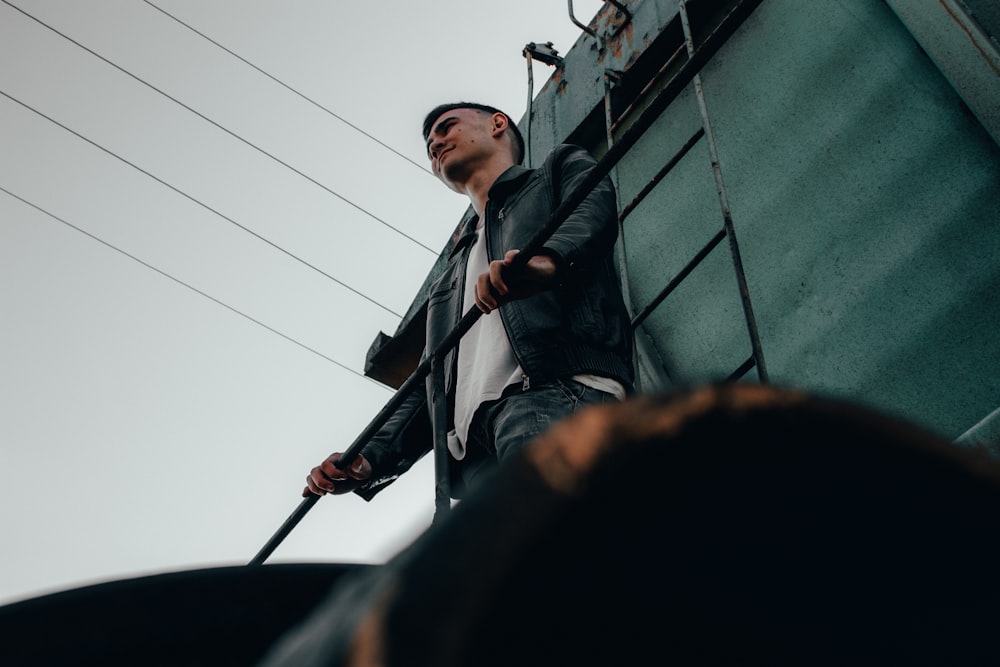 man in black jacket holding black stick