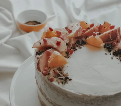 Close-up of a decadent layered cake topped with fresh tropical fruits