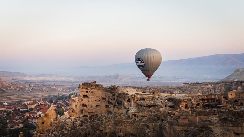 hot air balloon on top of brown rock formation during daytime