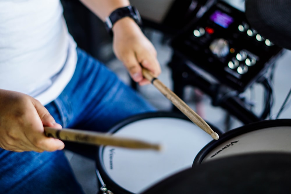 person in blue shirt playing drum