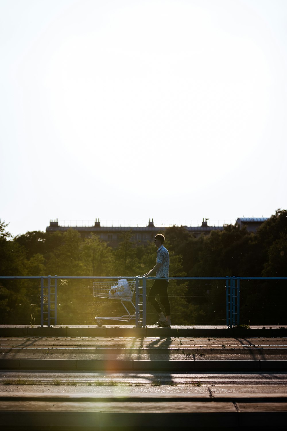 man in white shirt standing on bridge during daytime