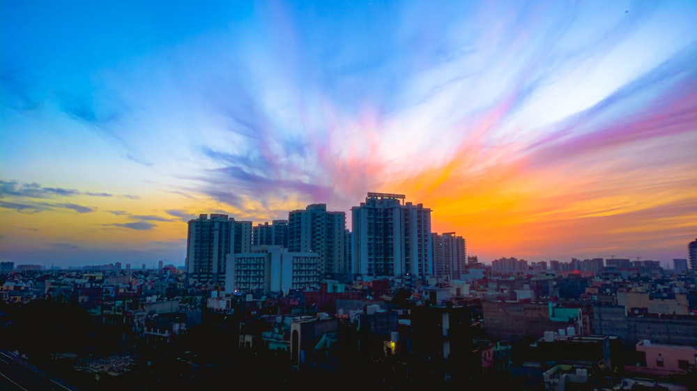 horizonte da cidade sob o céu azul e laranja durante o pôr do sol