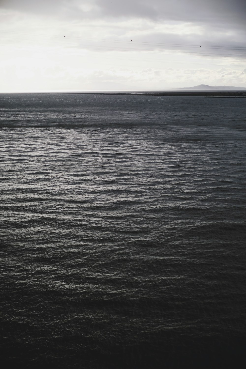 body of water under white sky during daytime