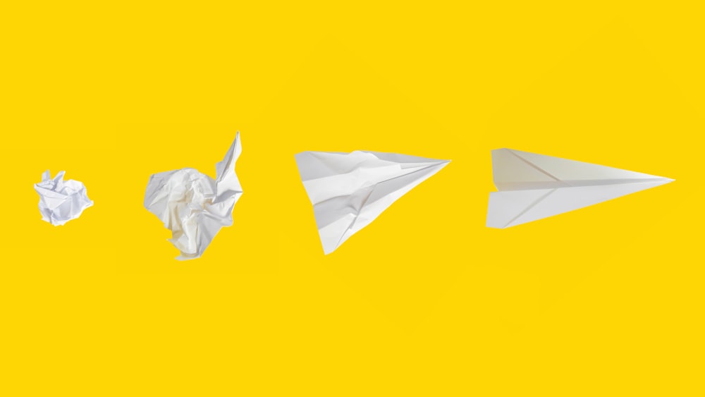 aeroplano di carta bianco su sfondo giallo