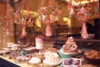An inviting bakery display featuring a variety of cakes with warm lighting.