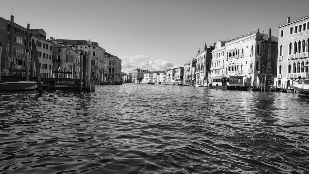 grayscale photo of body of water between buildings