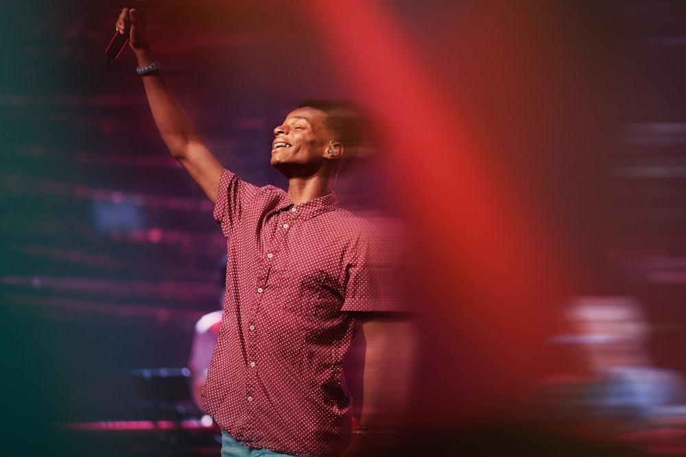 man in red and white plaid button up shirt holding microphone