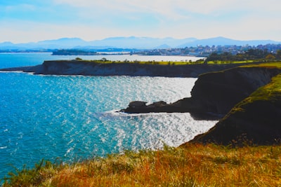 green grass field near body of water during daytime cabo verde teams background