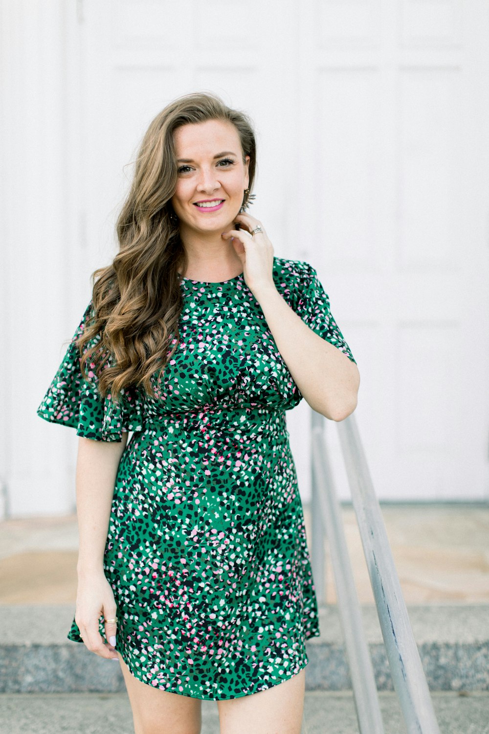 mulher no vestido verde e preto de pé nas escadas