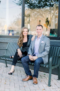 man in gray suit jacket sitting beside woman in black coat