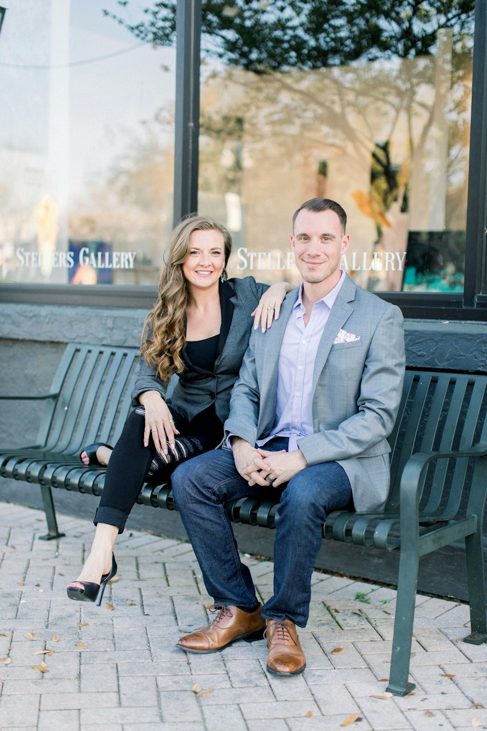 man in gray suit jacket sitting beside woman in black coat