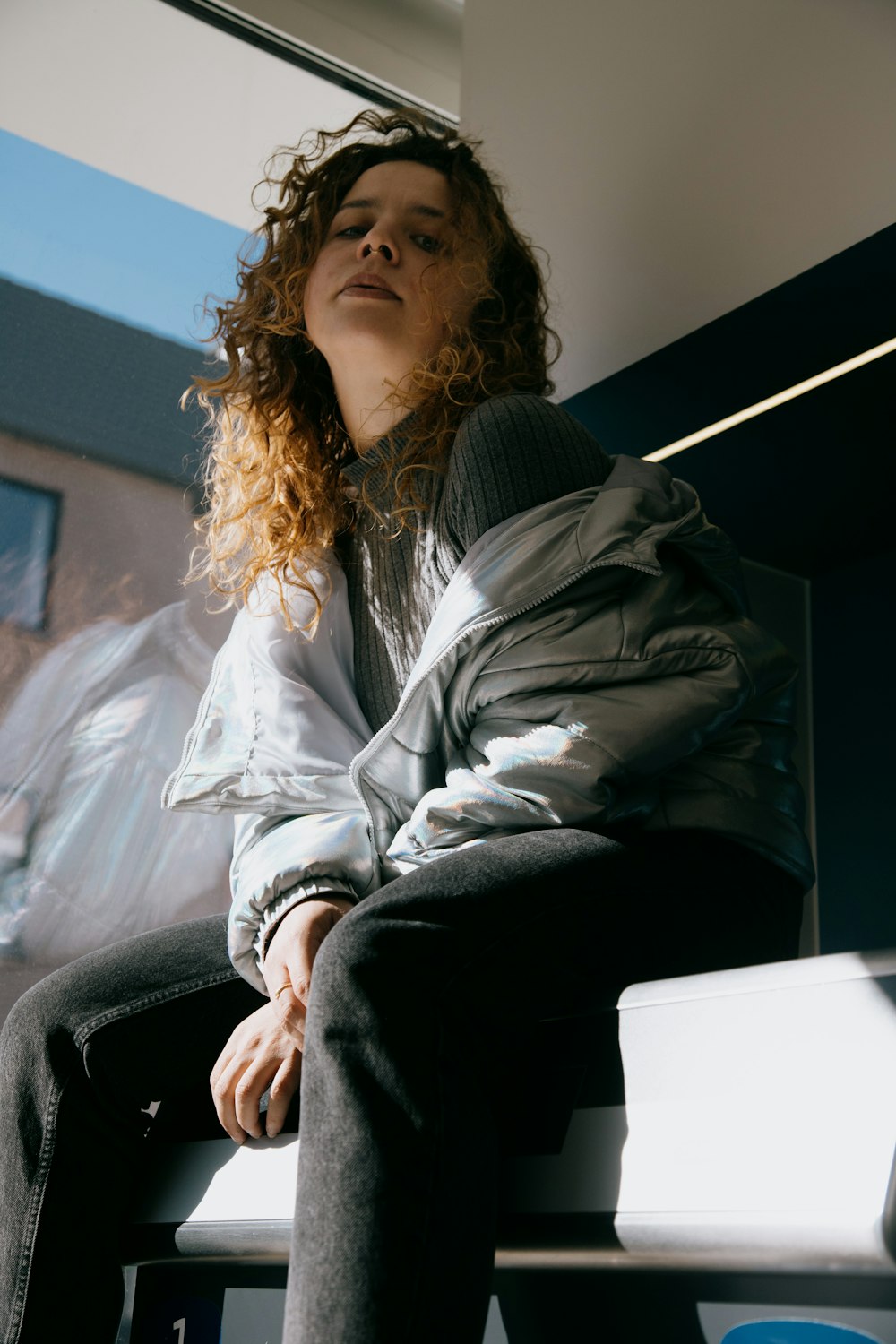 woman in gray jacket sitting on black couch