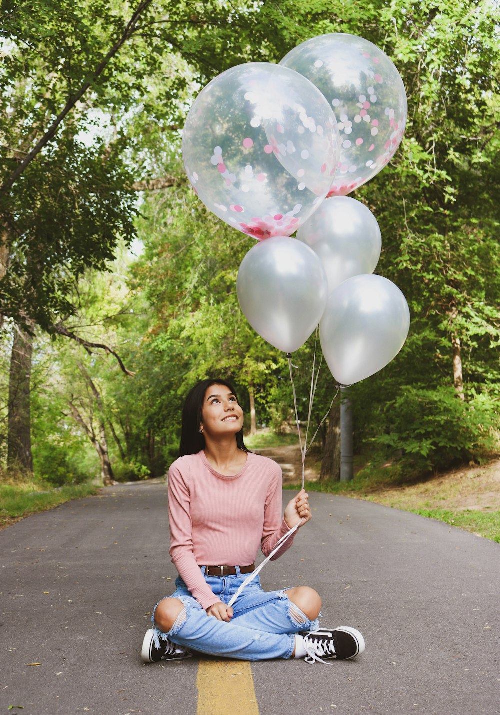 woman in gray scoop neck shirt holding balloons