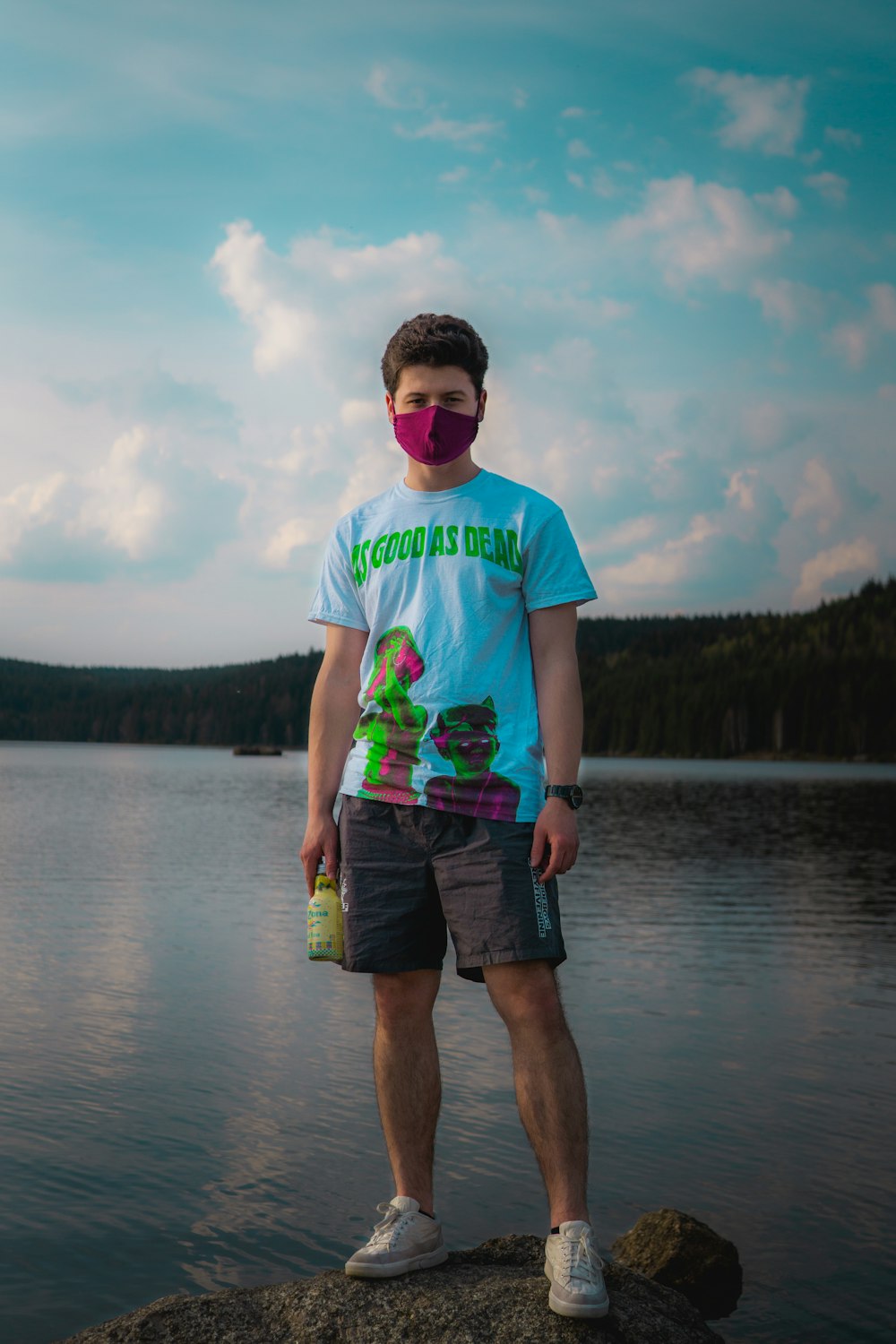 man in green and white crew neck t-shirt standing on lake during daytime