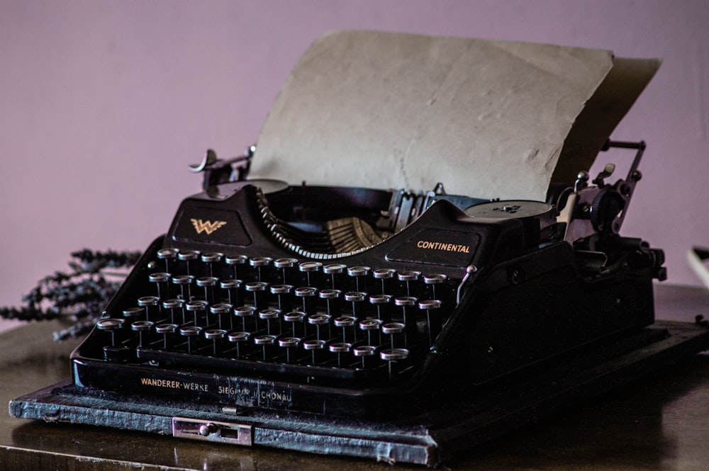 Máquina de escribir negra sobre mesa blanca
