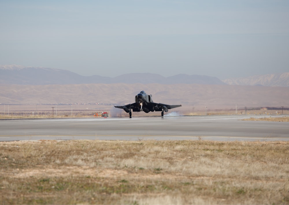 black fighter plane on gray field during daytime