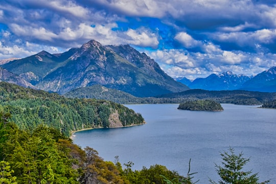 green trees near lake under blue sky and white clouds during daytime in Punto Panorámico Argentina