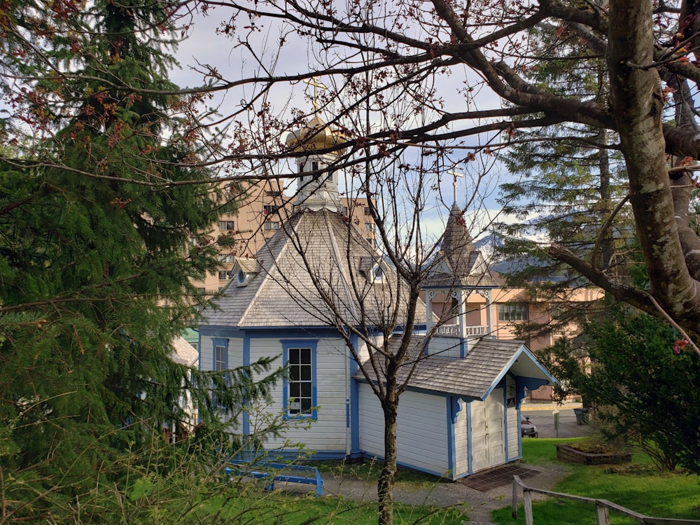 Casa bianca e marrone vicino agli alberi verdi durante il giorno