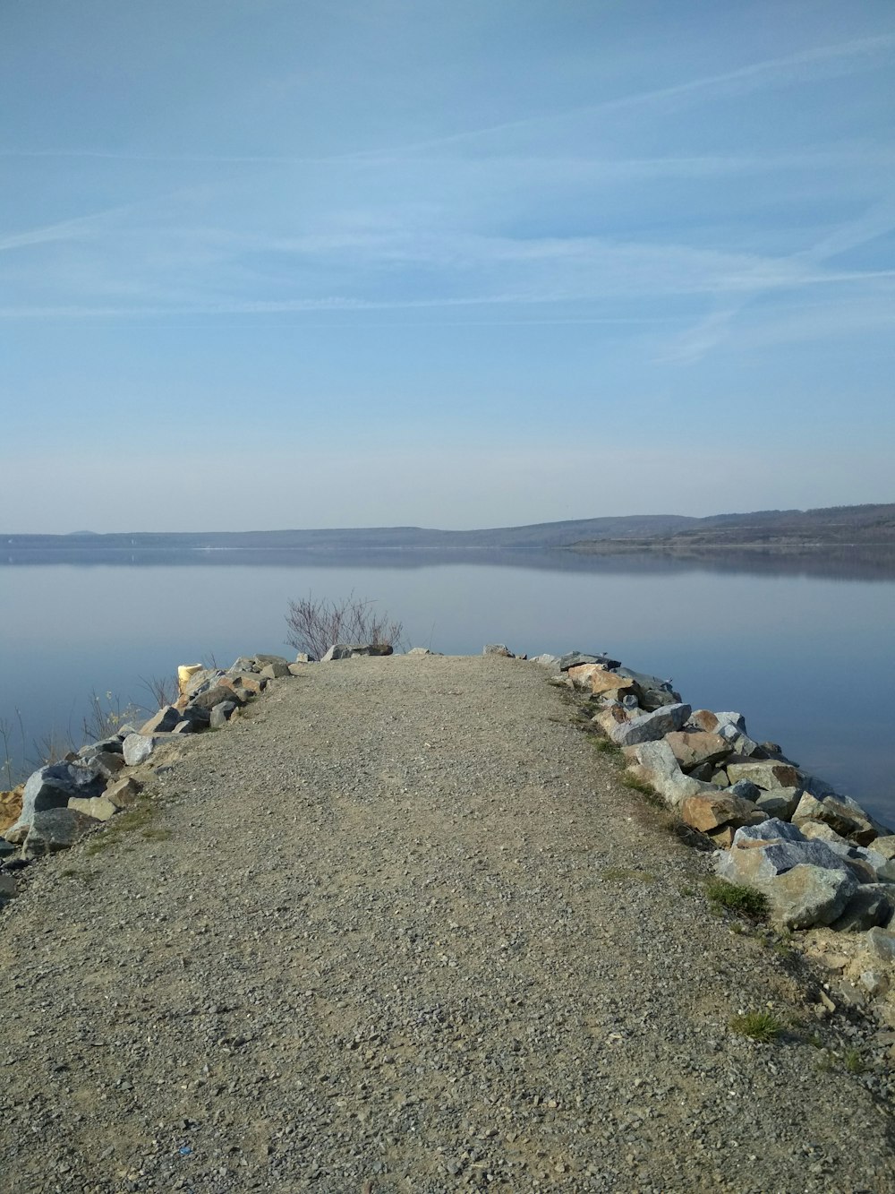 brown and gray rocky shore near body of water under blue sky during daytime