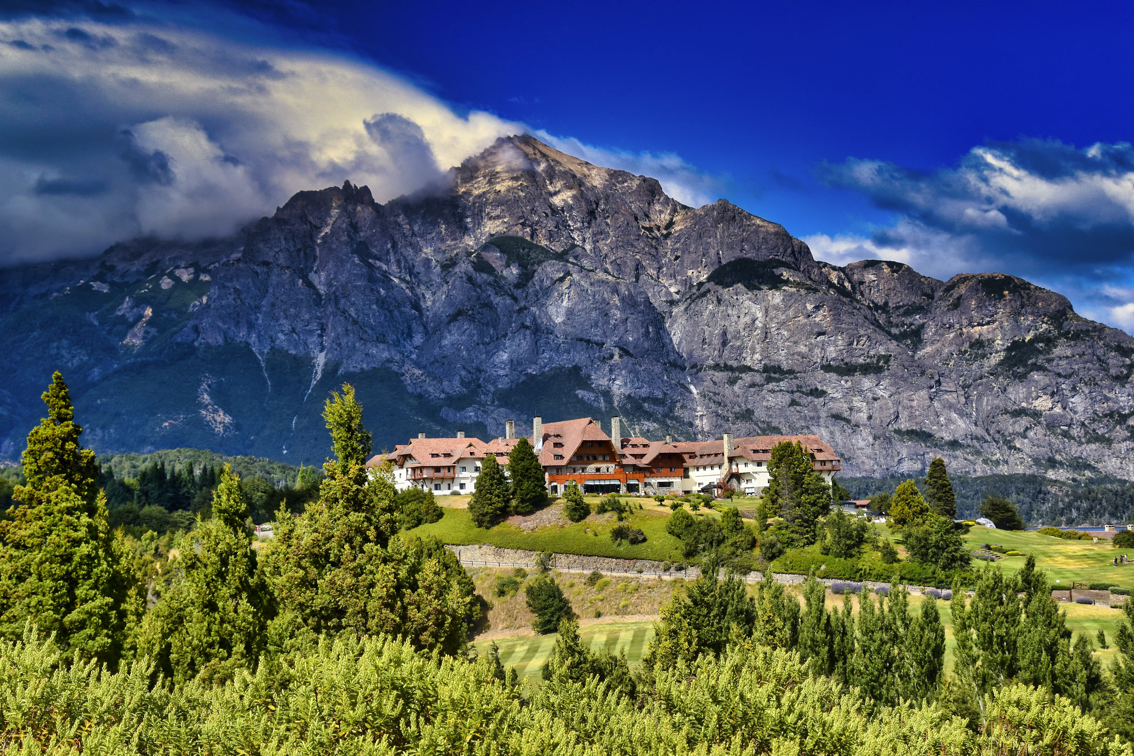 Hotel Llao Llao entre bosques con el cerro López y cielo azul en Bariloche