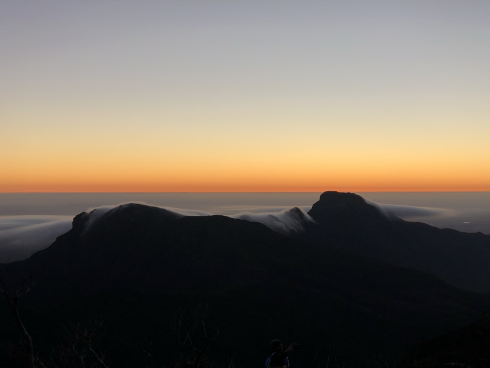 Silueta de la montaña durante la puesta del sol