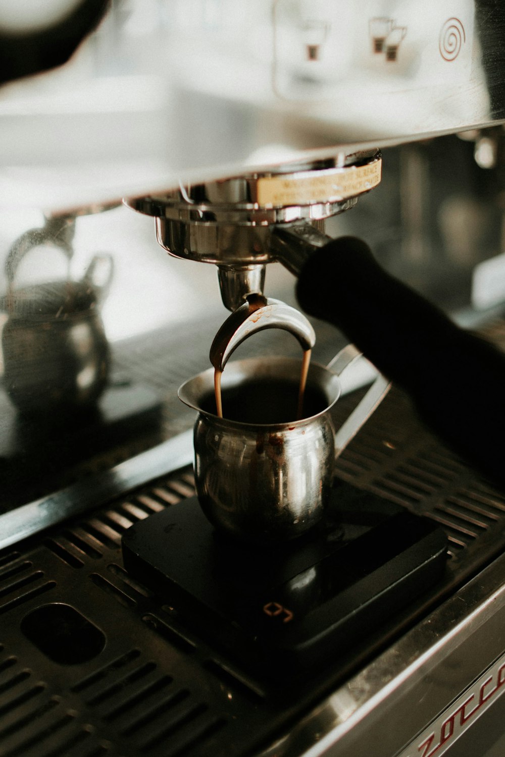 black ceramic mug on black metal coffee maker