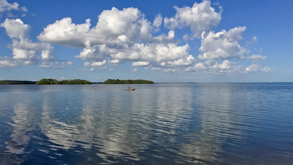 a small boat floating on top of a large body of water