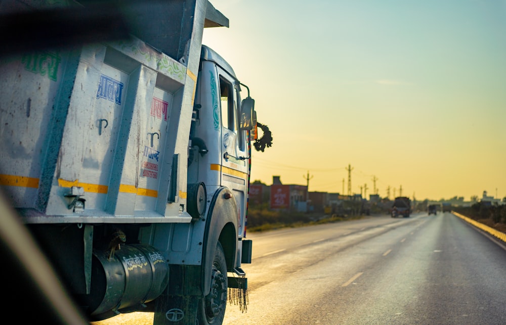 white and black truck on road during sunset