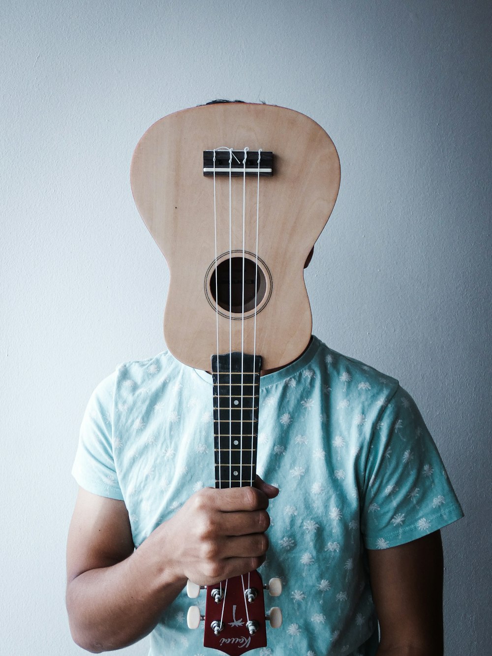 a man holding a ukulele in front of his face