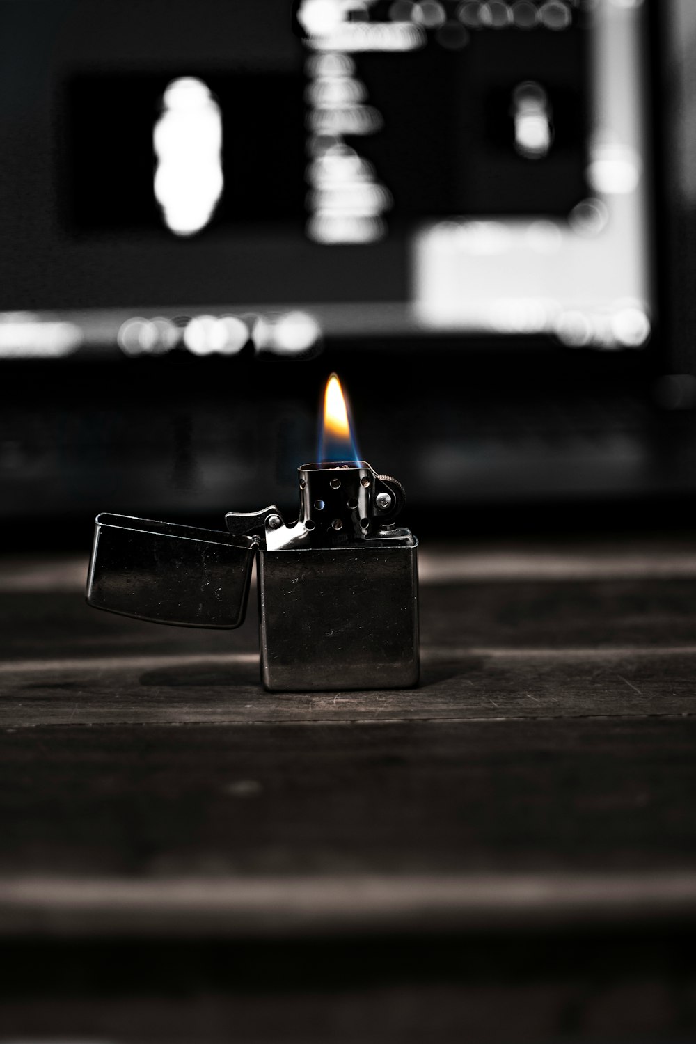 silver flip lighter on brown wooden table