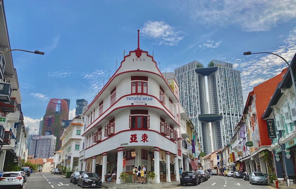 cars parked in front of white and red concrete building during daytime