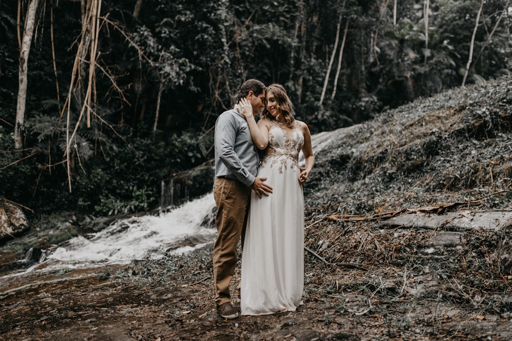 man and woman in wedding dress standing on brown dried leaves during daytime