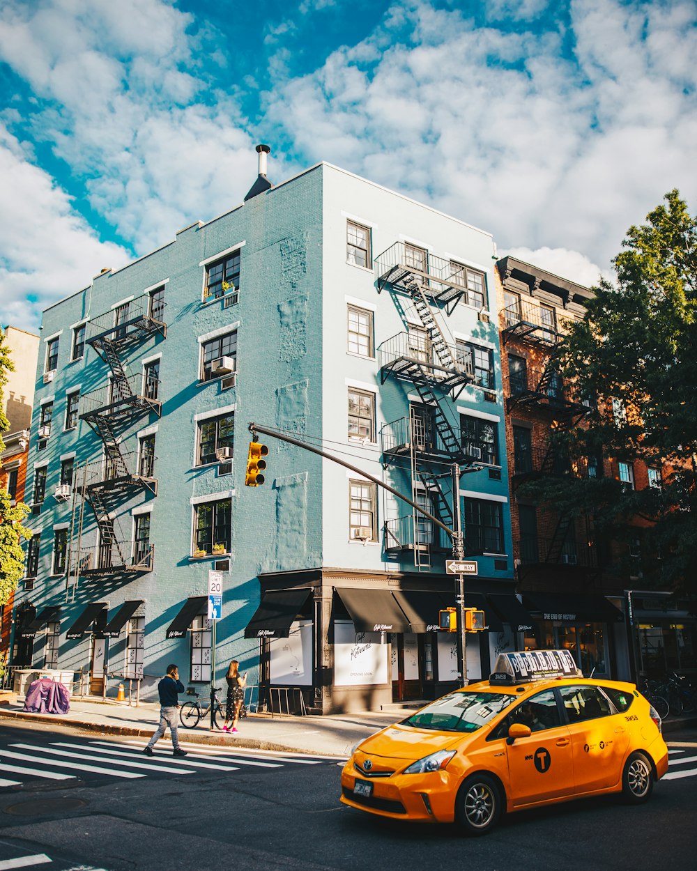 yellow taxi cab on road near building during daytime