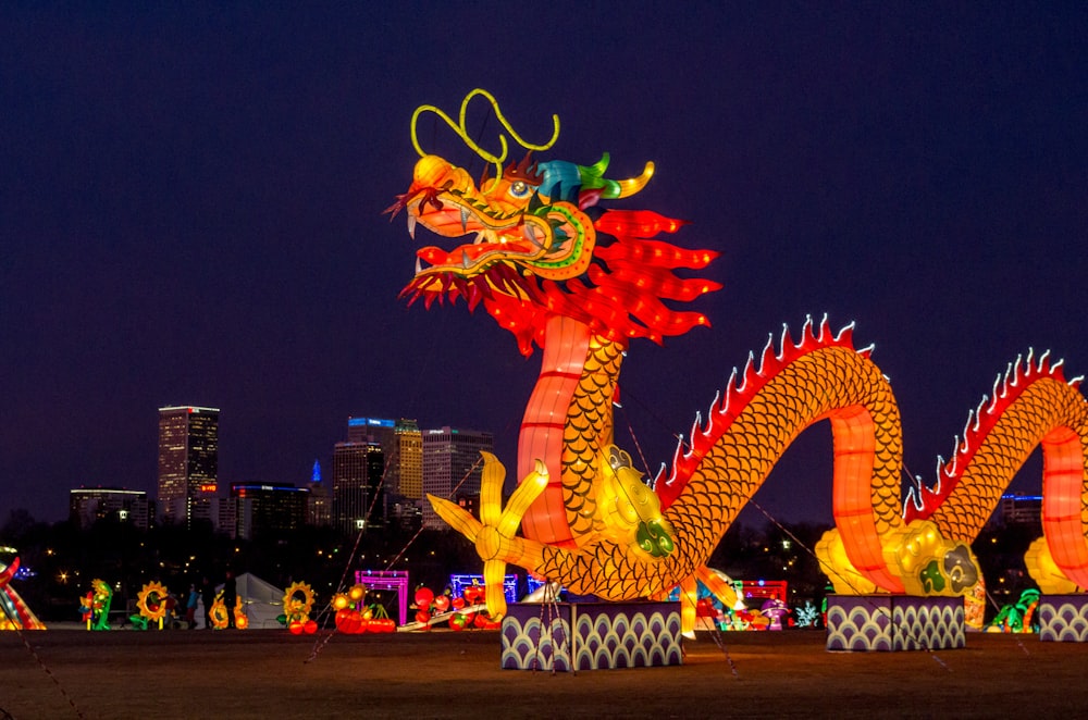 people walking on street with dragon statue during night time