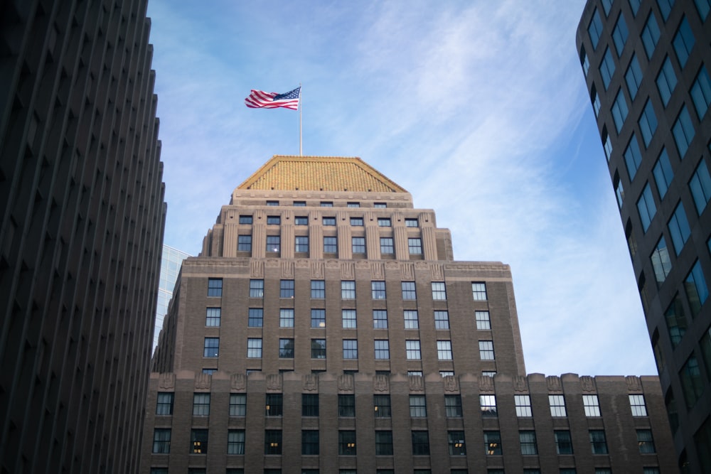 brown concrete building with flag of us a during daytime