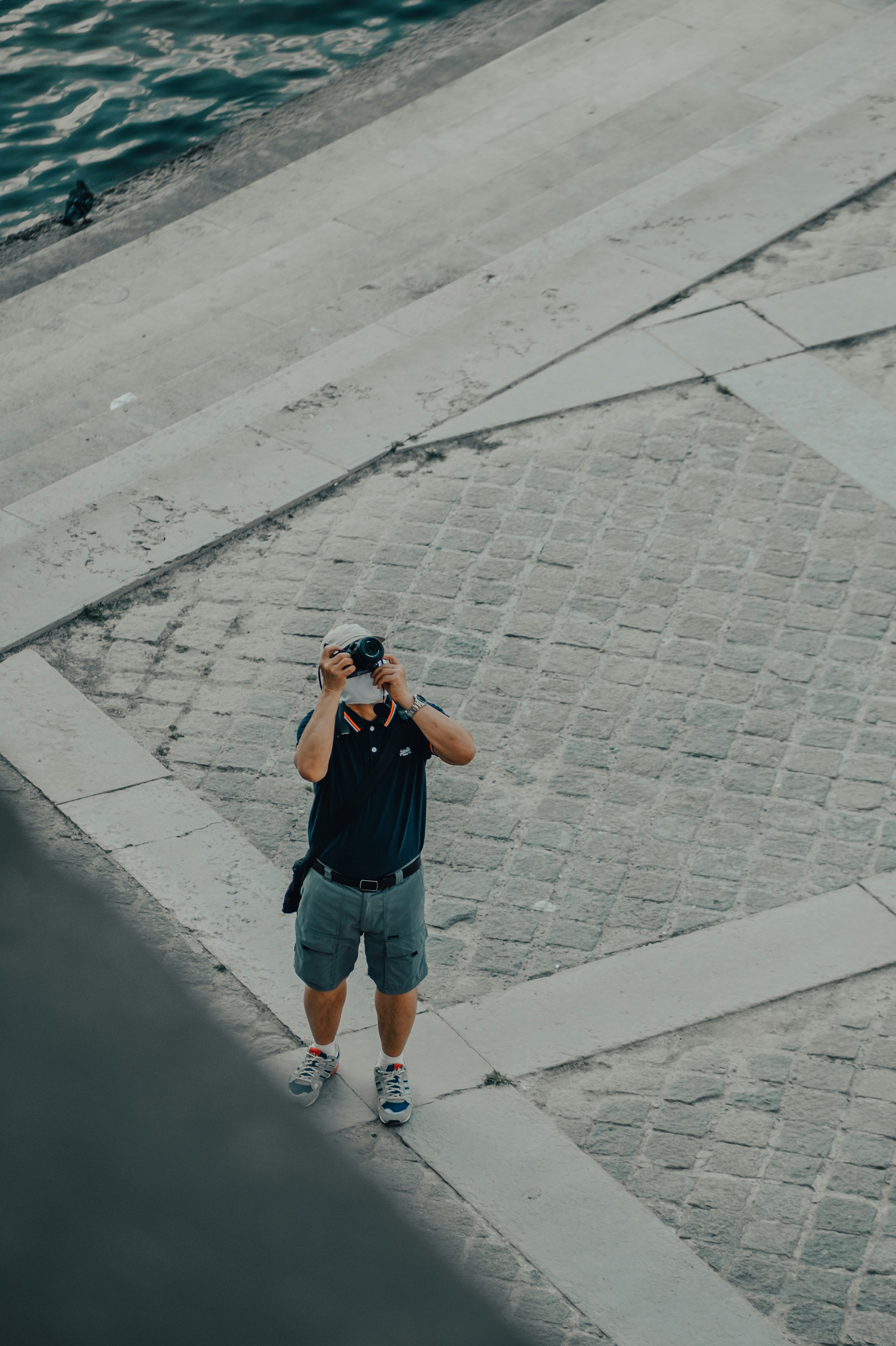 boy in blue denim shorts and gray t-shirt standing on gray concrete pavement