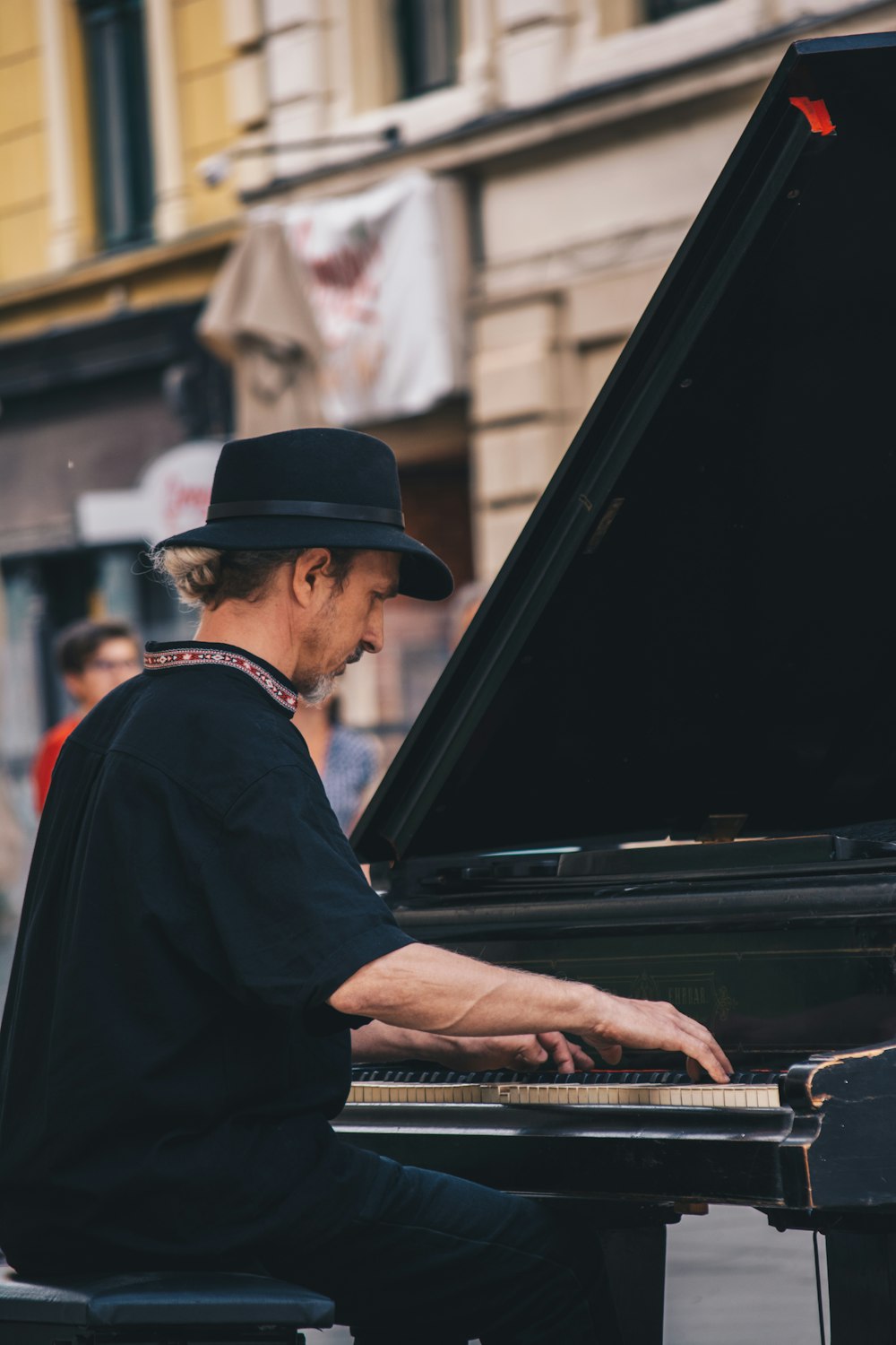 Mann im schwarzen Hemd spielt Klavier