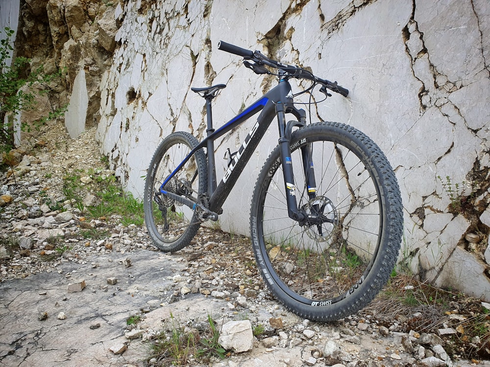 흰 벽에 기대어 파란색과 검은 색 산악 자전거