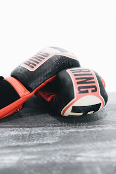 Close-up of vibrant Muay Thai gloves resting on traditional woven fabric.
