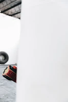 Close-up of boxing gloves striking a heavy bag in a modern gym setting.