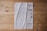 A document is laid out on a wooden surface. It appears to be a printed or photocopied sheet with tables and text written in Arabic. The paper is slightly crumpled and shows signs of wear. The wooden surface has a natural finish with visible knots and grain patterns.