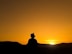 silhouette of man standing on hill during sunset