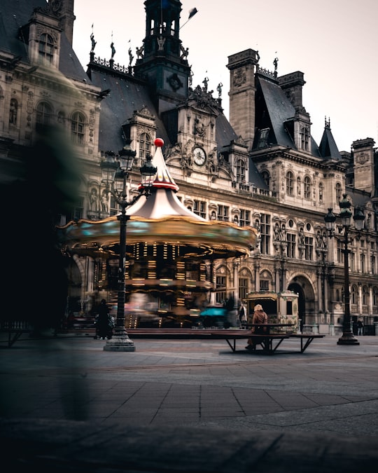 brown and black concrete building during night time in Hôtel de Ville France