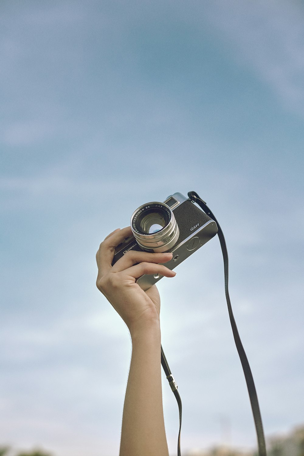 person holding black and silver camera